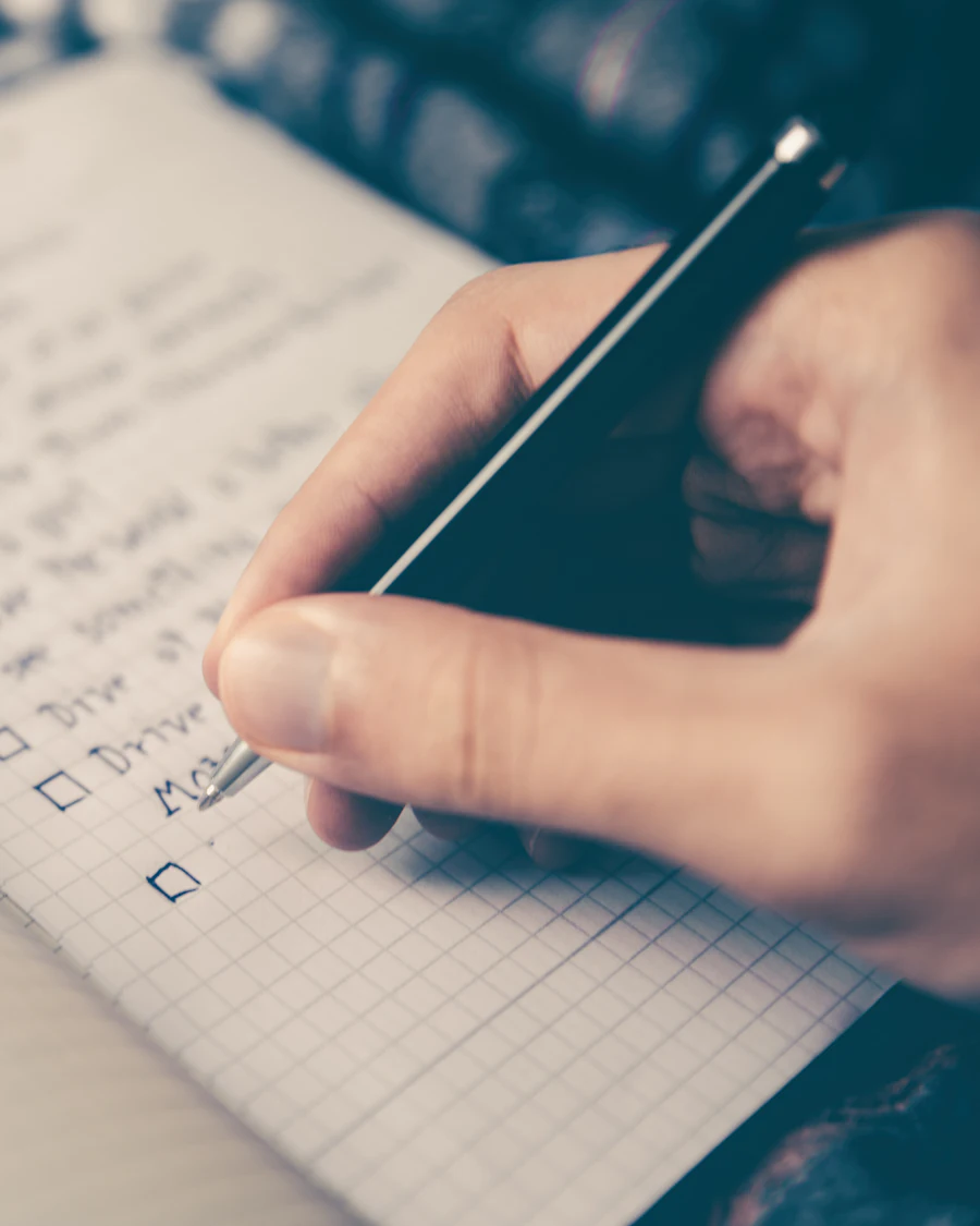 Hand ticking off a to-do list in a notebook